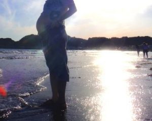 海で太陽をバックに撮るマタニティフォト